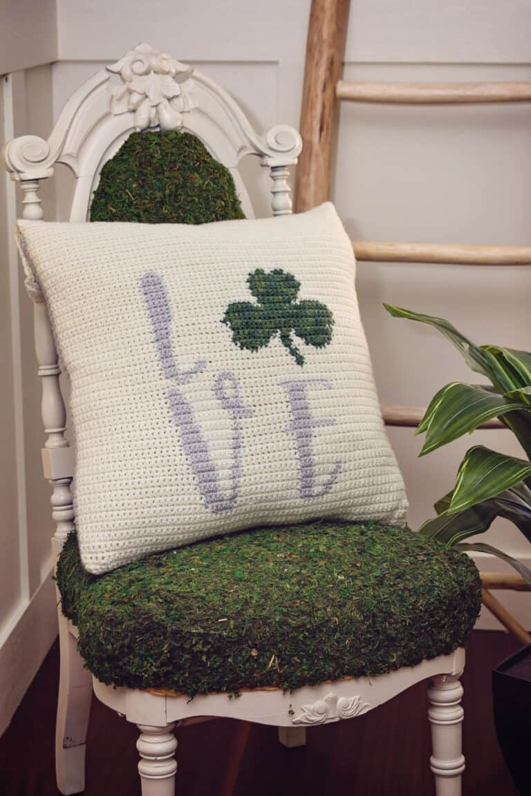A St. Patrick's crocheted pillow with a shamrock on it.