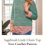 Smiling woman wearing a Sagebrush Lindy Chain Sweater over a pink shirt, standing indoors near a window.