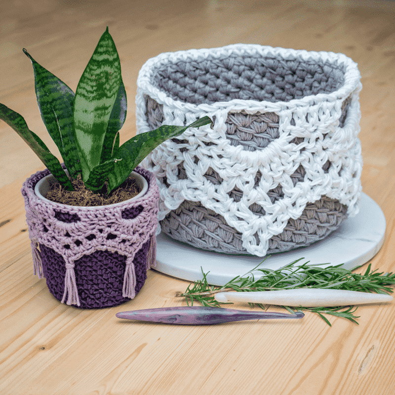 Two crocheted pots with a plant in them, made using a crochet basket pattern.