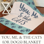Knitted crochet blanket and pillow with "You, Me & the Cats" and "Meow" text, displayed on a chair and floor; includes paw print designs—perfect for any cat or dog lover’s cozy space.