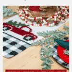 A Red Christmas Truck Table Runner, crocheted with a charming red truck design, is displayed on a wooden table adorned with greenery, wooden beads, and festive tableware.