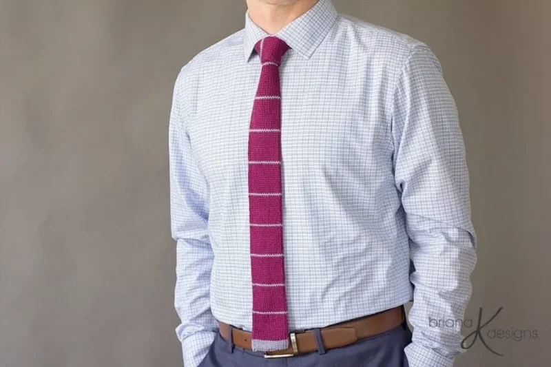 A man wearing a plaid shirt and Bradford knit tie pattern.