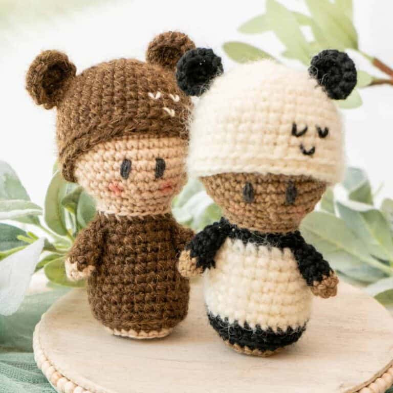 Two cute crocheted amigurumi panda bears on a plate.