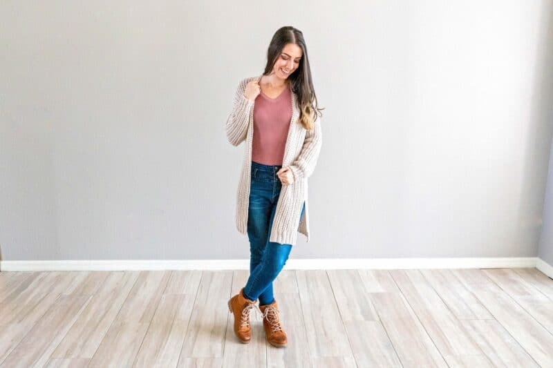 A woman standing in a room wearing jeans and a Campside Cardi.