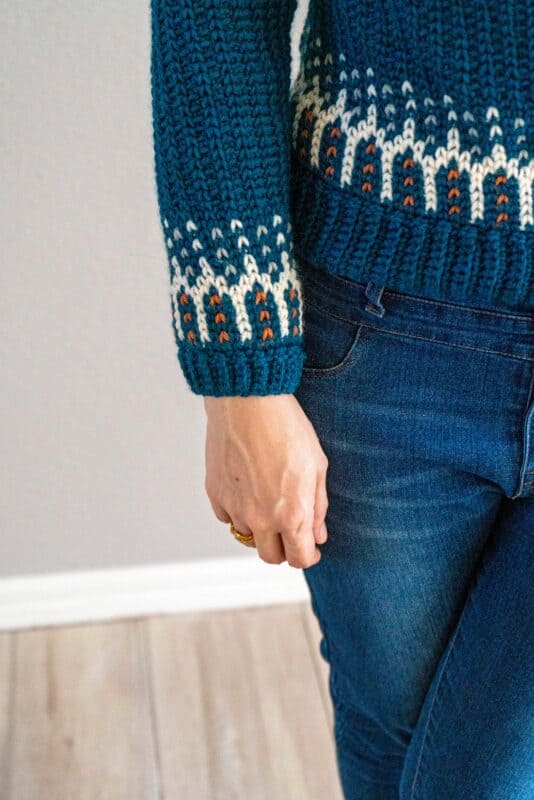 A woman wearing a blue fawning over you sweater.