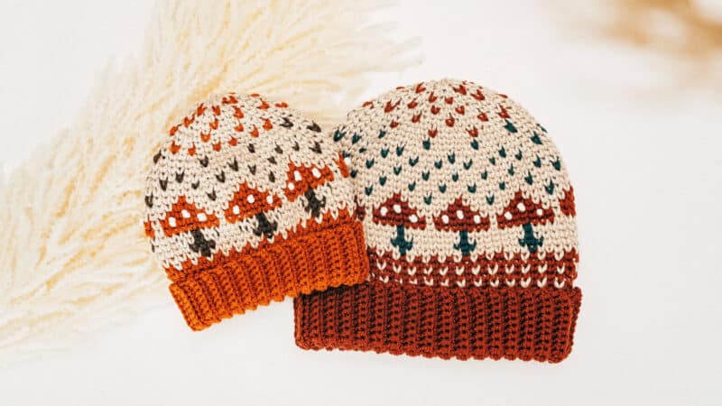 Two crochet mushroom hats on a white background.