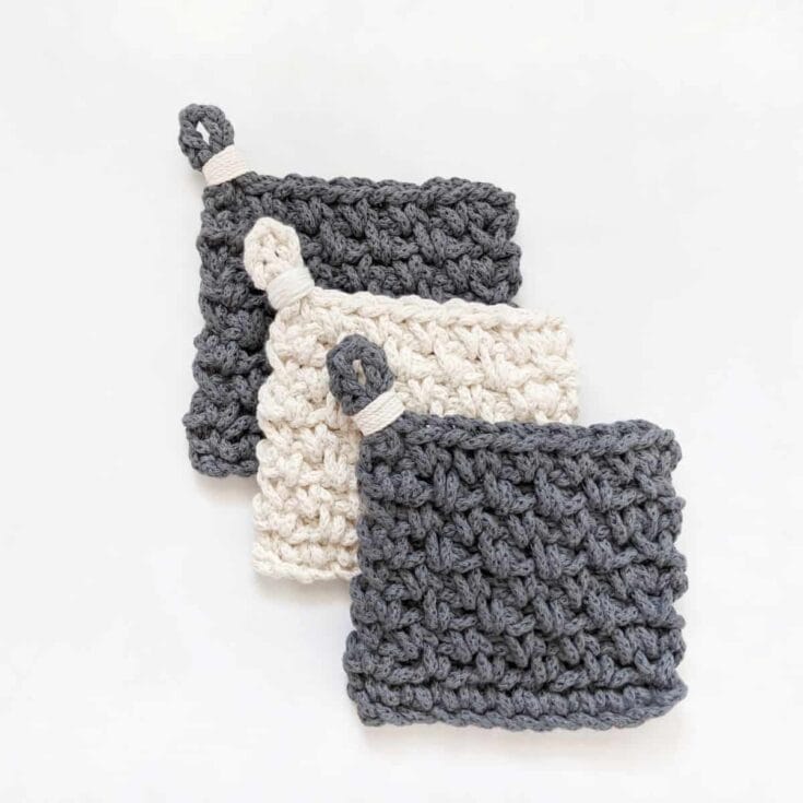 Three crocheted dishcloths on a white surface.