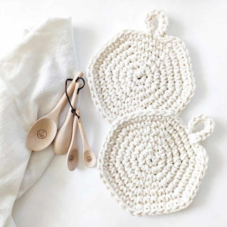 A set of crocheted pot holders and wooden spoons.
