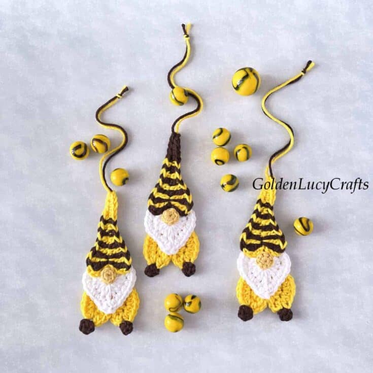 Three crochet gnome ornaments with bees on them.