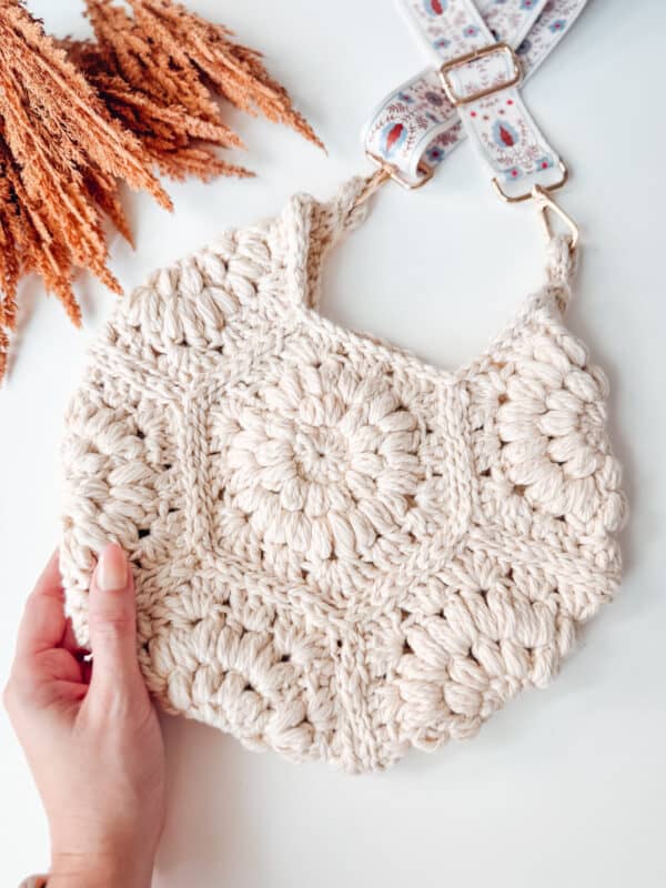 A person holding a crocheted bag.