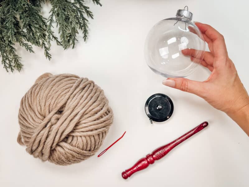 A person is holding a yarn ball while knitting.