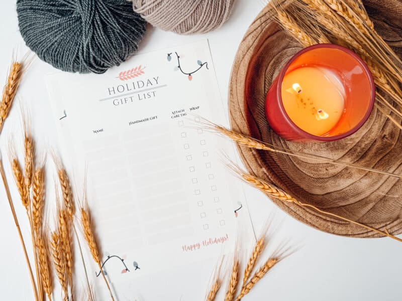 A knitter's holiday list with a candle and wheat.