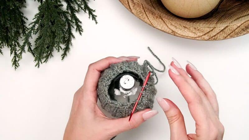 A hand holding a crocheted ball.