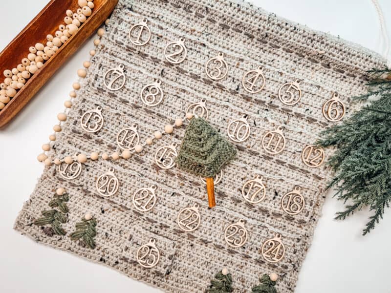 A Crochet advent calendar adorned with pine trees.