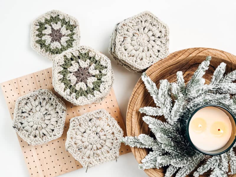 Crocheted hexagon coasters on a wooden table.