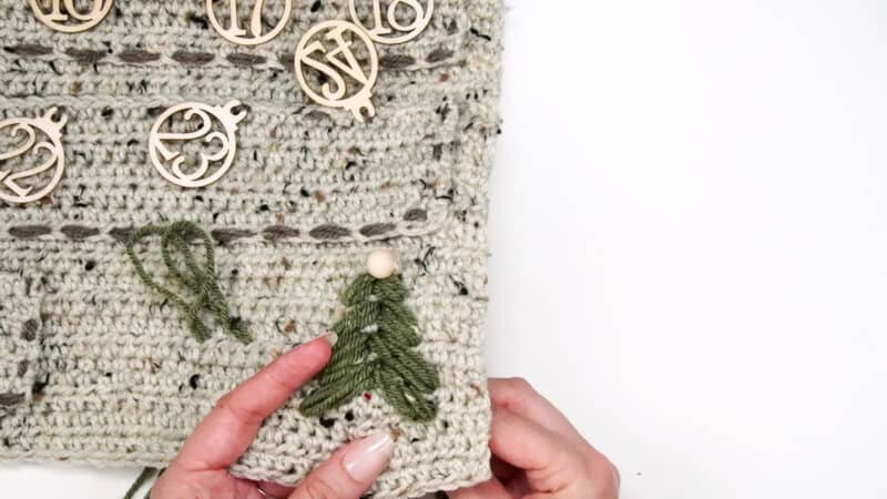 A person is knitting a crocheted Christmas tree using granny crochet.
