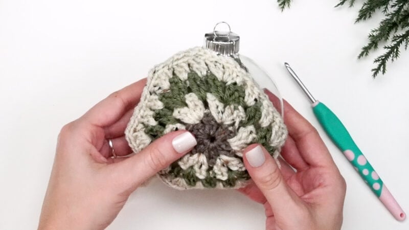 A person holding a Granny crocheted Christmas ornament.