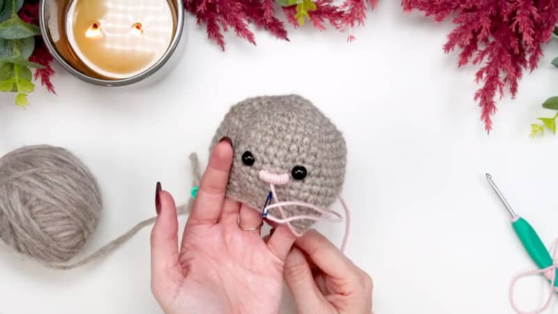 A person is crocheting a mouse.