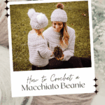 A woman and child wearing matching crocheted beanies and sweaters sit on grass holding a pine cone. Text promotes a free Crochet Beanie Pattern and video tutorial for making the cozy macchiato beanie.