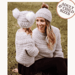 Adult and child wearing matching Child Crochet Sweater and hats sit on grass; text announces free pattern and video tutorial for making a crochet sweater in adult and child sizes.