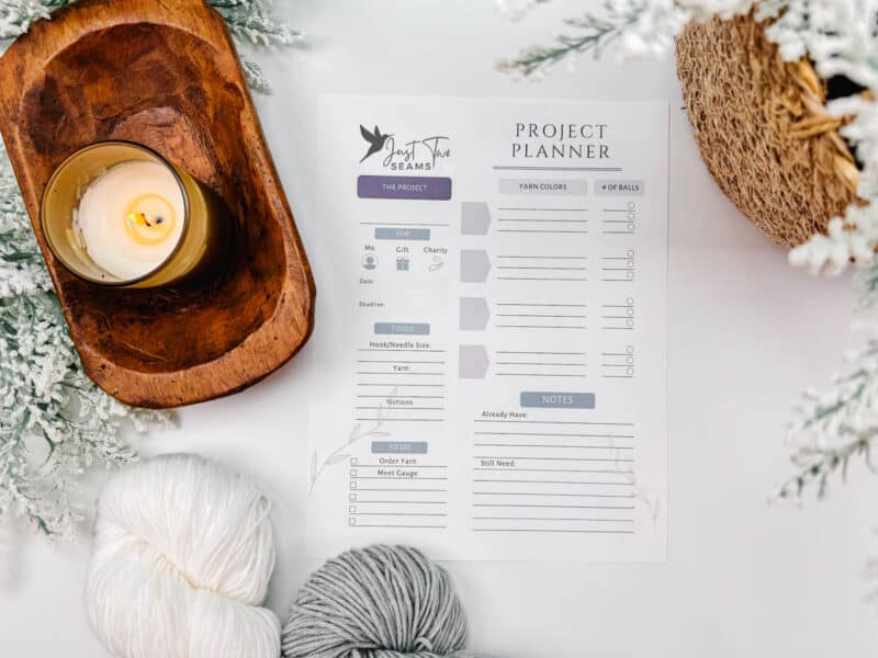 A project planner sheet from the Behind The Seams Crochet Collection with yarn and a lit candle on a festive background.
