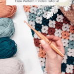 Hand holding a crochet hook over a multicolor granny stripe blanket, with balls of yarn nearby and text announcing the Colorful Hues Granny Stitch Blanket - Free Pattern and video tutorial.