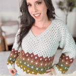 A woman is wearing a Granny Stitch pullover sweater in white, green, and brown hues. Text at the bottom reads, "Granny Stitch Pullover, Free Crochet Pattern + Video Tutorial, www.brianakdesigns.com.