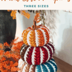 Three crocheted pumpkins in different colors and sizes are stacked on a table, with dried orange foliage in the background. Text promotes a free Pumpkin Spice Crochet Pumpkin Trio Pattern and video tutorial using the wheat stitch.