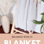 A knitted blanket hangs on a wooden ladder next to a vase of pampas grass. Text reads "Braided Wheat Blanket - Free Crochet Pattern + Video Tutorial" along with a website URL.