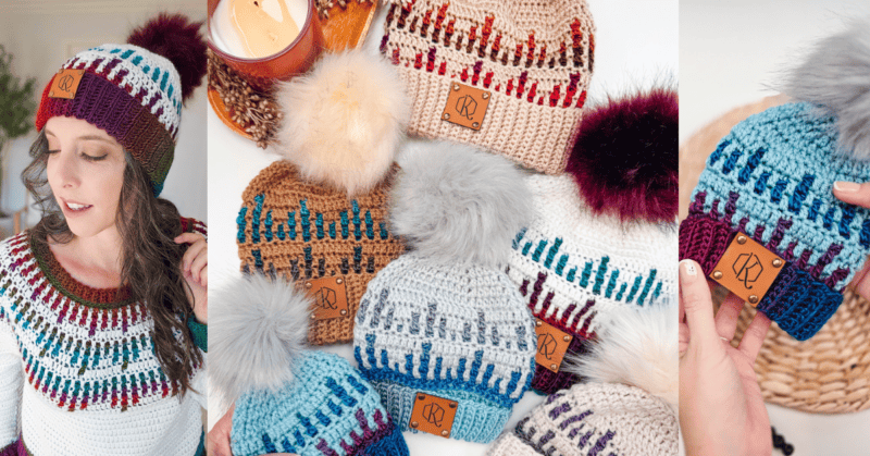 A woman wearing a crocheted beanie and sweater, with multiple beanies featuring pom-poms displayed beside her, and a candle in the background.