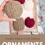 Hand holding a knitted ornament with others displayed on a tray. Text reads "Snowy Wheat Puff Stitch Ornaments. Free Pattern + Video Tutorial.