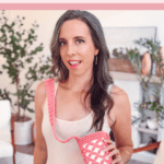 Woman holding a pink free crochet water bottle holder, standing in a living room with plants and mid-century modern furniture. Text reads: "Easy Summer Project Crochet Water Bottle Holder.