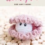 A crocheted pink clam amigurumi with a white, smiling face sits on a wood slice surface, with text offering a free crochet pattern and video tutorial.