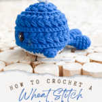 A small blue crocheted whale sits on a wooden surface, with text below advertising a Free Wheat Stitch Crochet Whale Pattern and video tutorial.