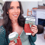 A woman holds a cup and a package, both wrapped in crochet cup cozies with a pumpkin spice label. Text above advertises a free crochet pattern and video tutorial for a wheat stitch cup cozy.
