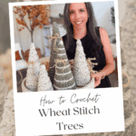 A woman sits at a table displaying crochet wheat stitch trees in various sizes. The image promotes a free pattern and video tutorial for making the trees.