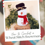 A crocheted snowman with a black hat and red scarf sits on a wooden surface with greenery, promoting a free pattern and video tutorial for a wheat stitch snowman.