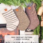 Three crocheted Christmas stockings hang from a mantle decorated with greenery; text overlay advertises a free crochet pattern and video tutorial for a wheat stitch stocking.