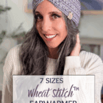 A woman with long gray hair wears a knitted purple earwarmer and smiles at the camera. Text overlay reads: "7 Sizes Wheat Stitch crochet earwarmer pattern. Free Pattern + Video Tutorial.
