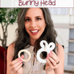 Woman holding two crochet projects, including a white bunny head, sits indoors. Text on image reads: "How to Crochet a Bunny Head. Free Pattern + Video Tutorial.