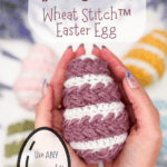 Hands holding a crocheted Easter egg with white and purple stripes; text promotes a free pattern and video tutorial for making a Wheat Stitch Easter Egg.