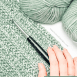 A hand holds a crochet hook on a partially completed green piece with two skeins of yarn nearby. Text reads, "Lightweight, stylish, and easy to customize. Try this crochet cardigan pattern—start your project now.