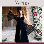 Woman in a black dress displays a black crochet wrap outside near a stone archway decorated with pink and white flowers. Text reads: "Easy Crochet Wrap. Lightweight, Beginner-Friendly—perfect for the Willow Mesh Stitch crochet tutorial.