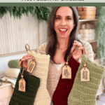 Woman smiling and holding three crocheted Christmas stockings in green, red, and cream colors, each with a gift tag, in a cozy home setting.