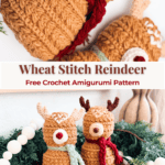 Two crocheted reindeer with scarves are displayed on a wooden tray, surrounded by greenery and festive decor. A "Wheat Stitch Reindeer Free Crochet Amigurumi Pattern" label appears in the center.
