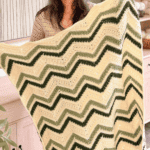 Woman holding a handmade chevron blanket with green and cream stripes; text reads "Petal Loop Stitch Chevron Blanket www.brianakdesigns.com".