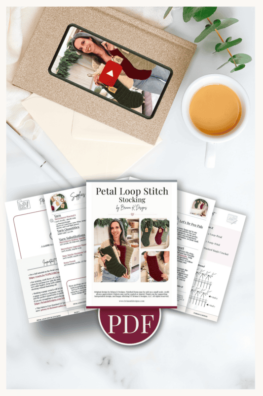A knitting pattern PDF for a petal loop stitch stocking is displayed with a cup of tea, leaves, and printed instruction pages arranged around a tablet showing the finished stocking.