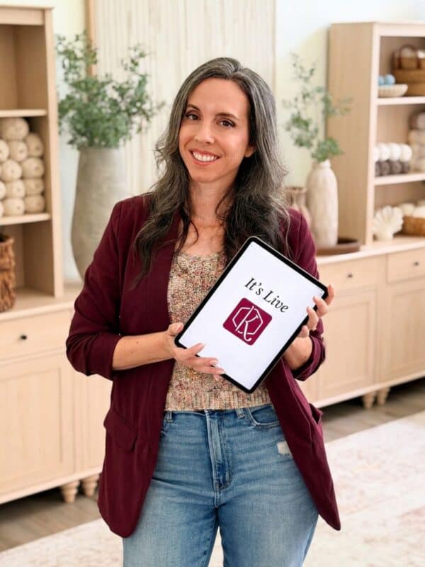 Briana K holding an iPad showing her app