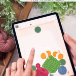 A person enjoys a crochet game on their tablet, surrounded by yarn and greenery, with the website brianakdesigns.com visible at the bottom.