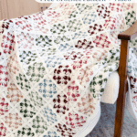 Crocheted granny square blanket with multicolor floral patterns draped over a chair; text advertises a free crochet pattern and video at brianakdesigns.com.